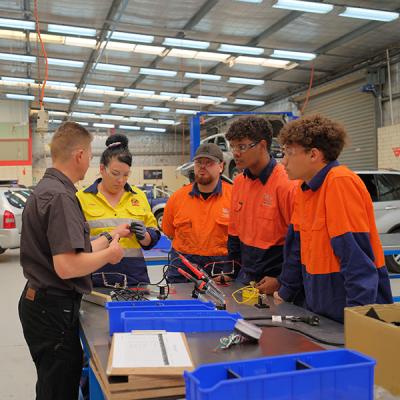 Decorative image - automotive students in the workshop with a lecturer (NMTAFE)
