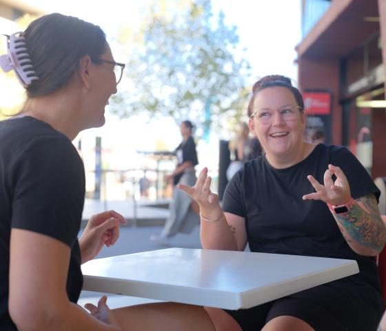 Two women using Auslan signs
