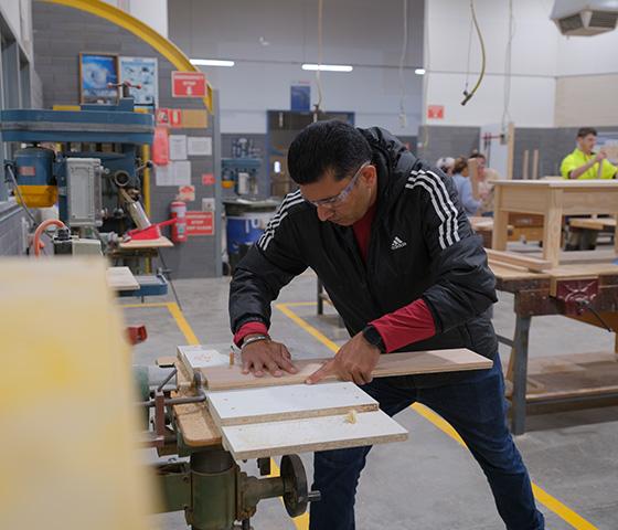 Male student using a furniture making machine, photo by Sav Subedi for NMTAFE
