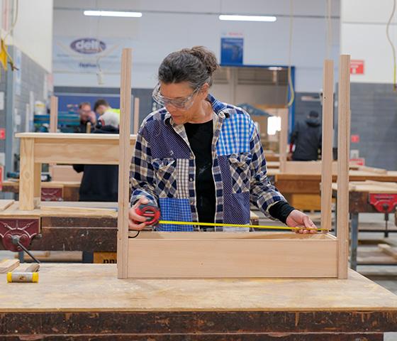 Female student measuring furniture, photo by Sav Subedi for NMTAFE
