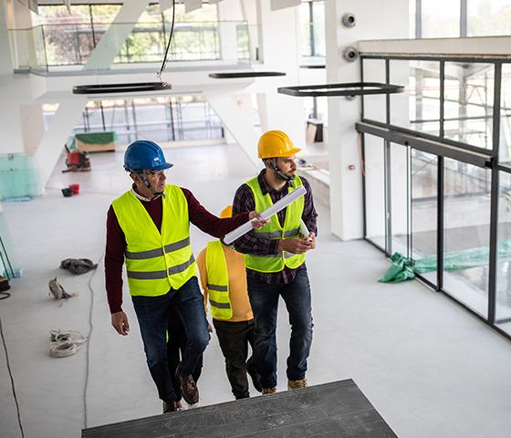 Decorative image - glazier and building project manager wearing PPE walking through a new commercial building under construction (iStock: miodrag ignjatovic)