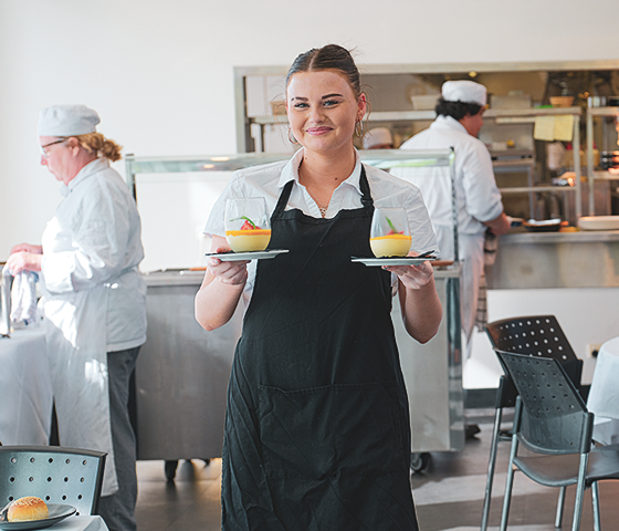 Decorative image - student carrying desserts (NMTAFE)
