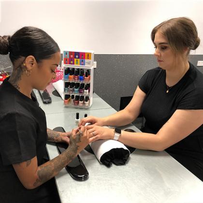 Student giving a manicure to a client in the NMTAFE training salon