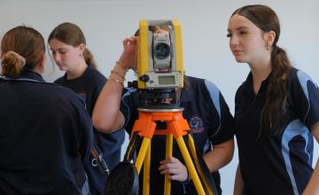 Two students participating in surveying